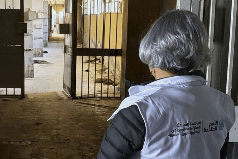 تقف السيدة كارلا كوينتانا، رئيسة المؤسسة المستقلة للأشخاص المفقودين في الجمهورية العربية السورية، مرتديةً سترة الأمم المتحدة ، عن مركز أخبار الأمم المتحدة لزيارةرئيس المؤسسة المستقلة للمفقودين في سوريا سجن صيدنايا وساحة المرجة بدمشق